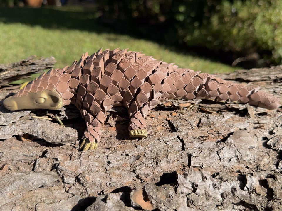 Brown and Gold Let's Live Pangolin Toy on Log