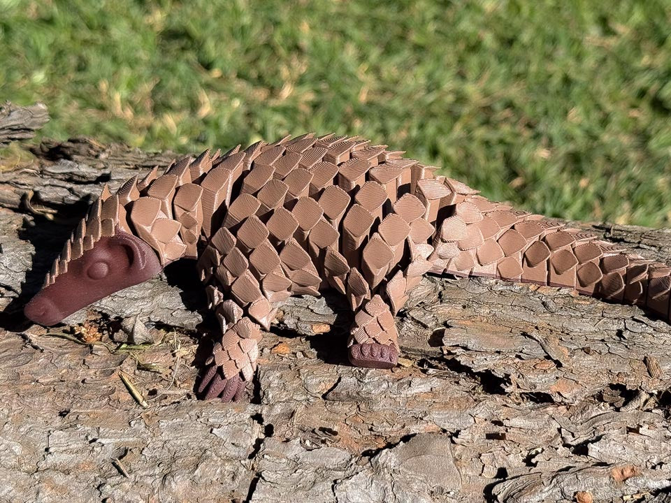 Brown and wood Let's Live Pangolin Toy on Log