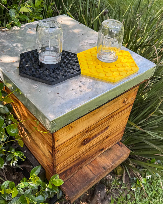 Wooden bee hive with two mason jars to provide the bees with a safe water source