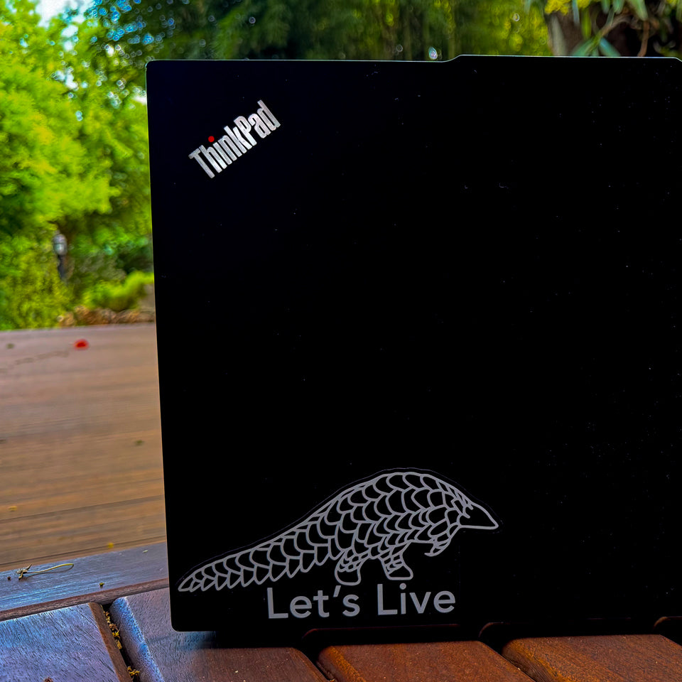 White Pangolin Sticker on Laptop with Let's live Text