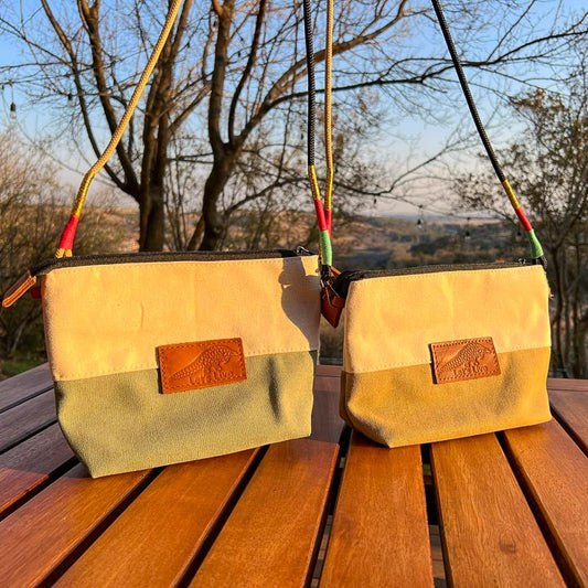 Two beige hand bags with leather Let's Live Pangolin patches hanging