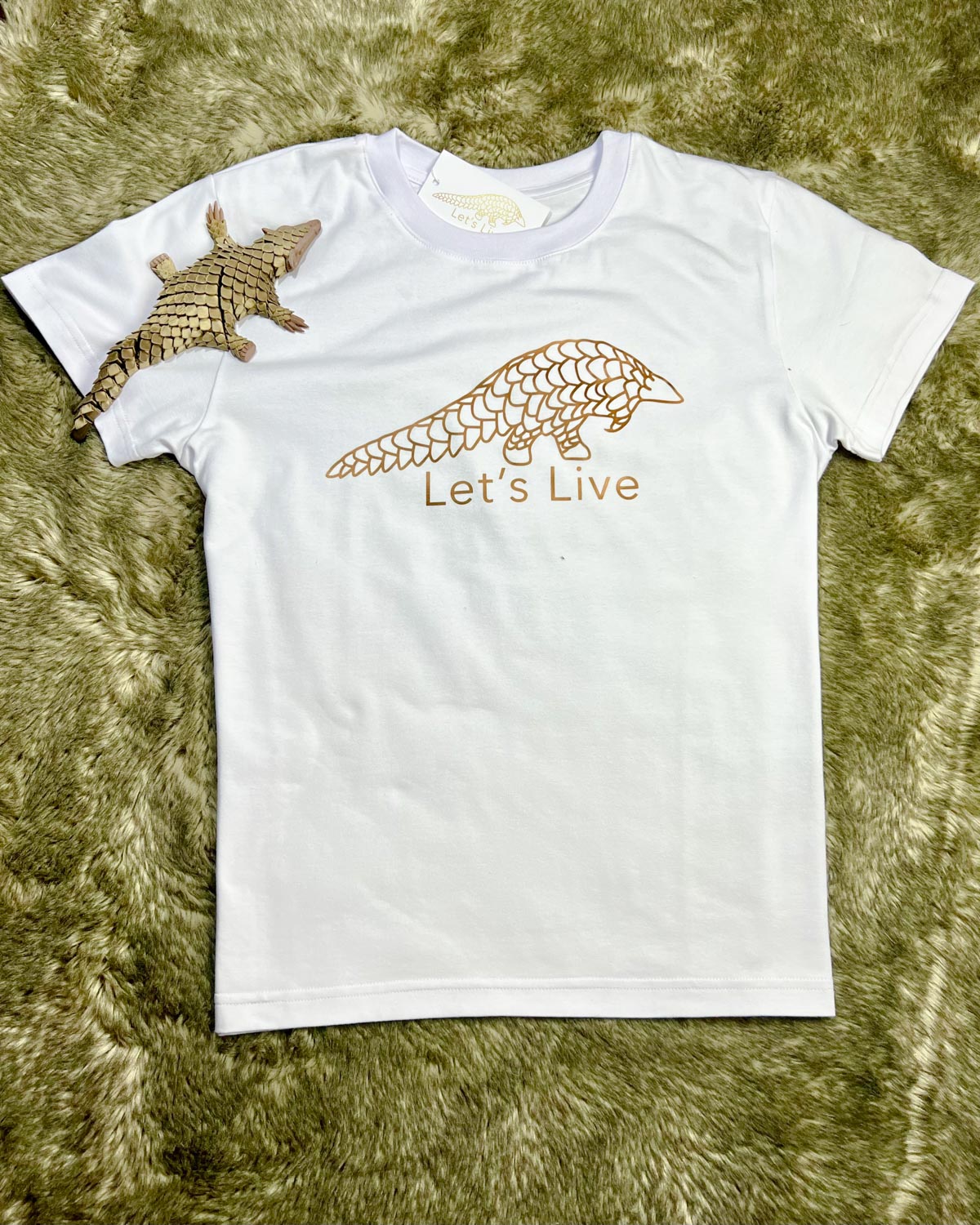 White Let's Live Pangolin Shirt with Bronze Pangolin Ambassador Figure on top of it