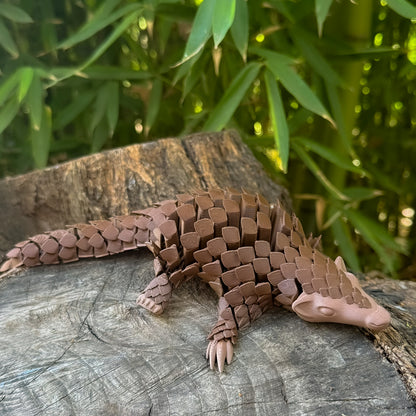 Brown Pangolin Toy on a wooden log