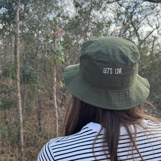lady wearing a green bucket hat with 'LET'S LIVE' text